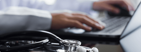 Doctor typing on a laptop