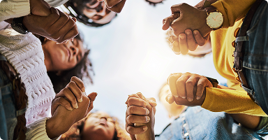 People holding hands and standing in a circle